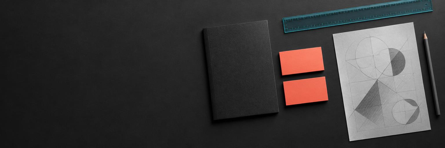 Coral brand stationery and design studies on a charcoal studio desk